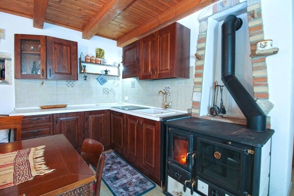 A kitchen with wooden cabinets, a stove, and a tiled backsplash.