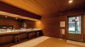 A modern bathroom with wooden paneling, a large mirror, and a sink with stools. - Caesar Gora Club Hakone (Hakone)