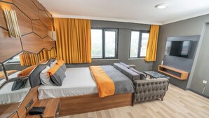 A modern bedroom with a large bed, a sofa, a TV, and a desk. - 216 F&B Suites (Istanbul)
