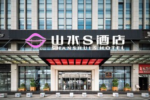 The entrance of the Shan Shui Hotel with a modern facade, large windows, and a prominent hotel sign. - Shanshui S Hotel  (Wuhan)