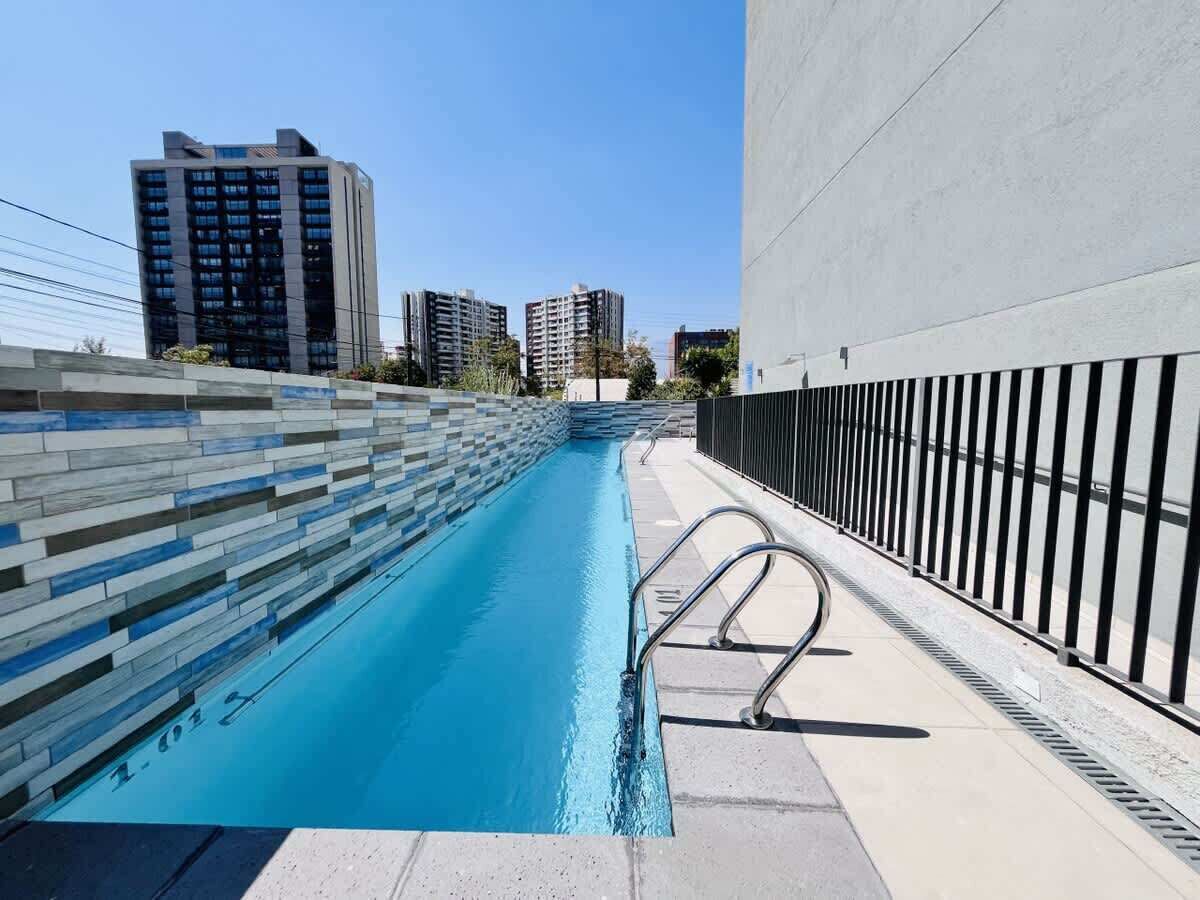 Sleek rooftop pool w/ city skyline views & lounge chairs for sunny afternoons