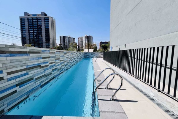 Sleek rooftop pool w/ city skyline views & lounge chairs for sunny afternoons