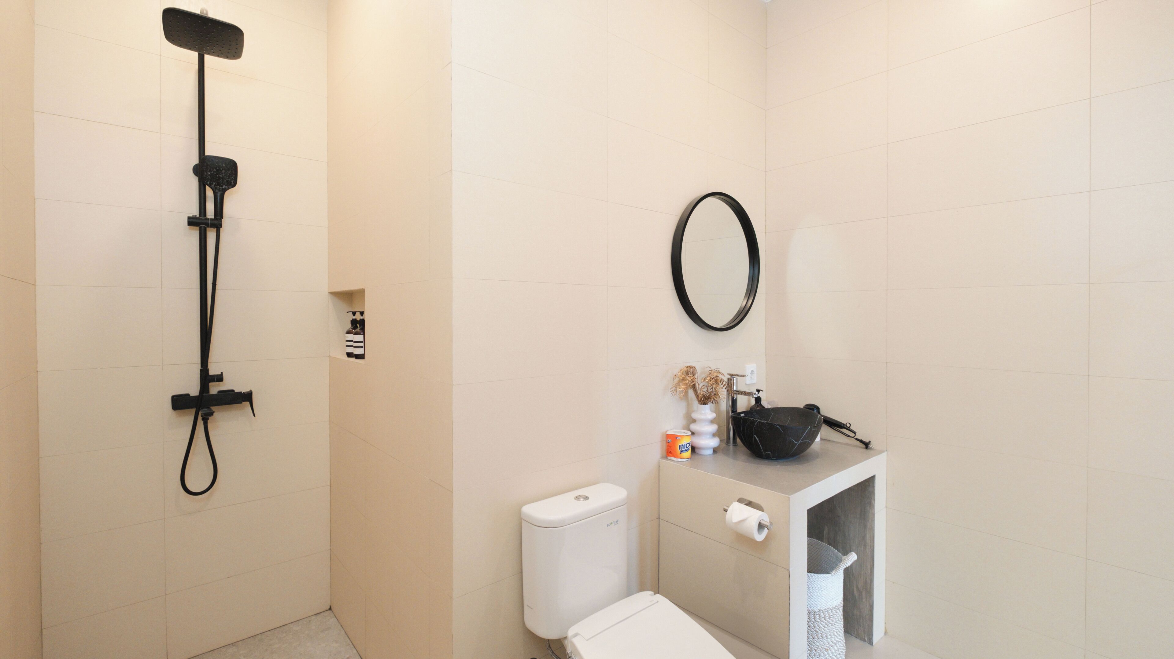 Un baño con ducha, inodoro, lavabo y toallero.
