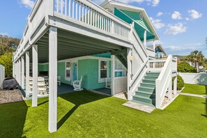 A two-story house with a covered porch, a staircase, and a well-maintained lawn. - Updated 3-bedroom, 2 bath coastal cottage across from the beach UNIT A (Fernandina Beach)