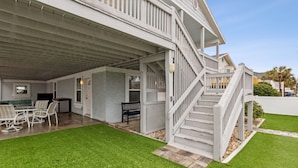 A covered outdoor area with a patio, a staircase, and a lawn. - Updated 3-bedroom, 2 bath coastal cottage across from the beach UNIT B (Fernandina Beach)
