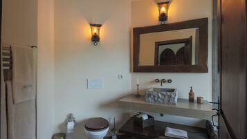 A bathroom with a toilet, sink, and towel rack.