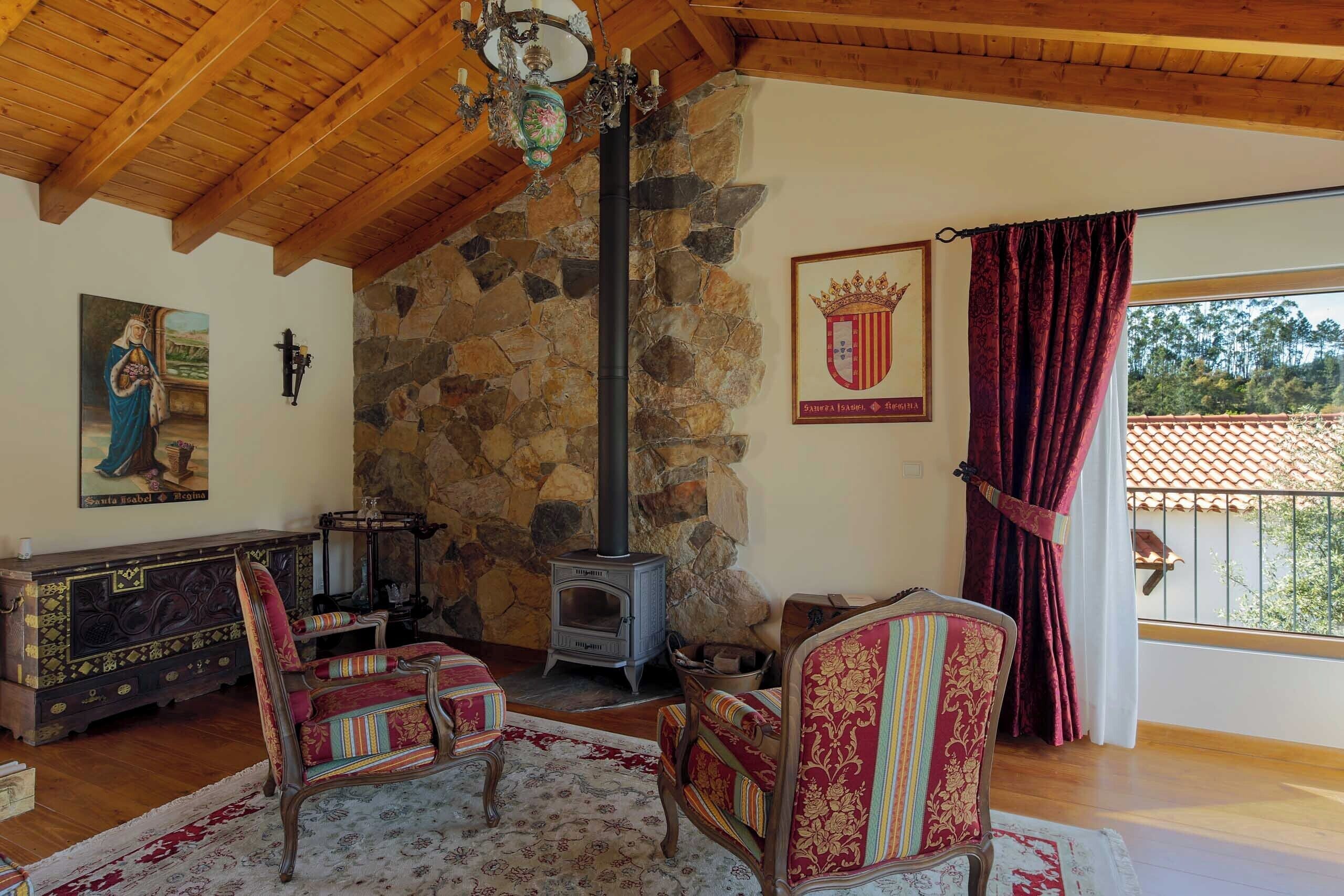 A cozy room with a stone wall, a wood-burning stove, and traditional furniture.