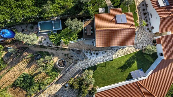 Vista aérea de una propiedad con piscina, zona de patio y un camino de piedra.
