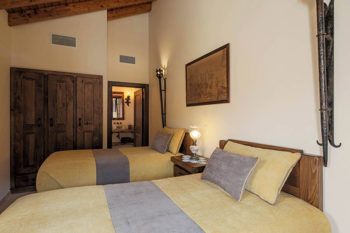 Une chambre avec deux lits, une armoire en bois et un tableau au mur.