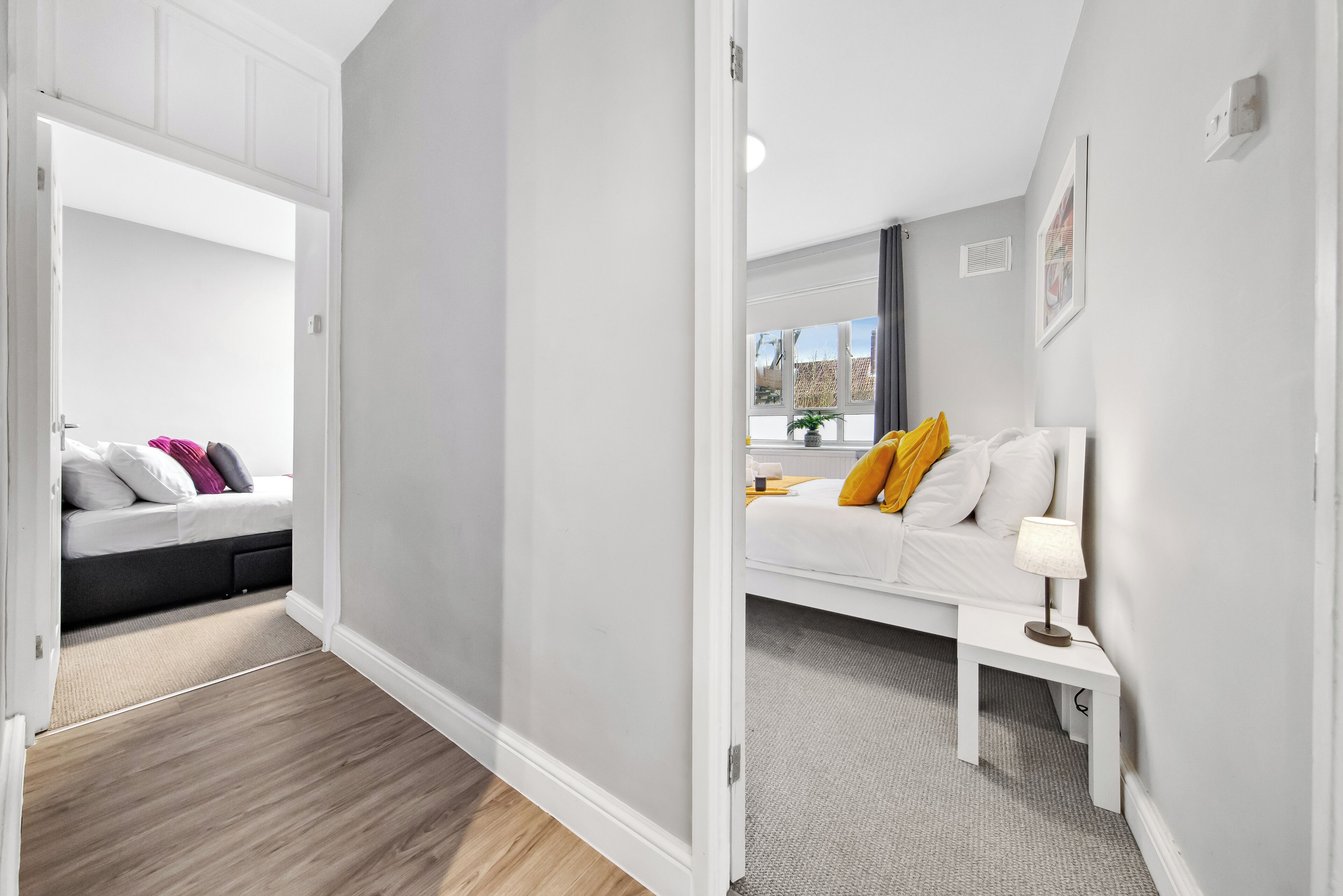 A modern bedroom with a bed, bedside table, and a window.