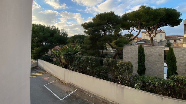 Un quartier résidentiel doté d’une route asphaltée, d’une place de stationnement et d’un mur en pierre.