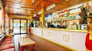 A restaurant with a counter, seating area, and decorative statues. - Sinsiamresort (Klaeng)
