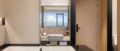 Un baño moderno con una bañera grande, un lavabo y un espejo.