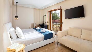 Un dormitorio con cama, sofá, televisión, escritorio y balcón.