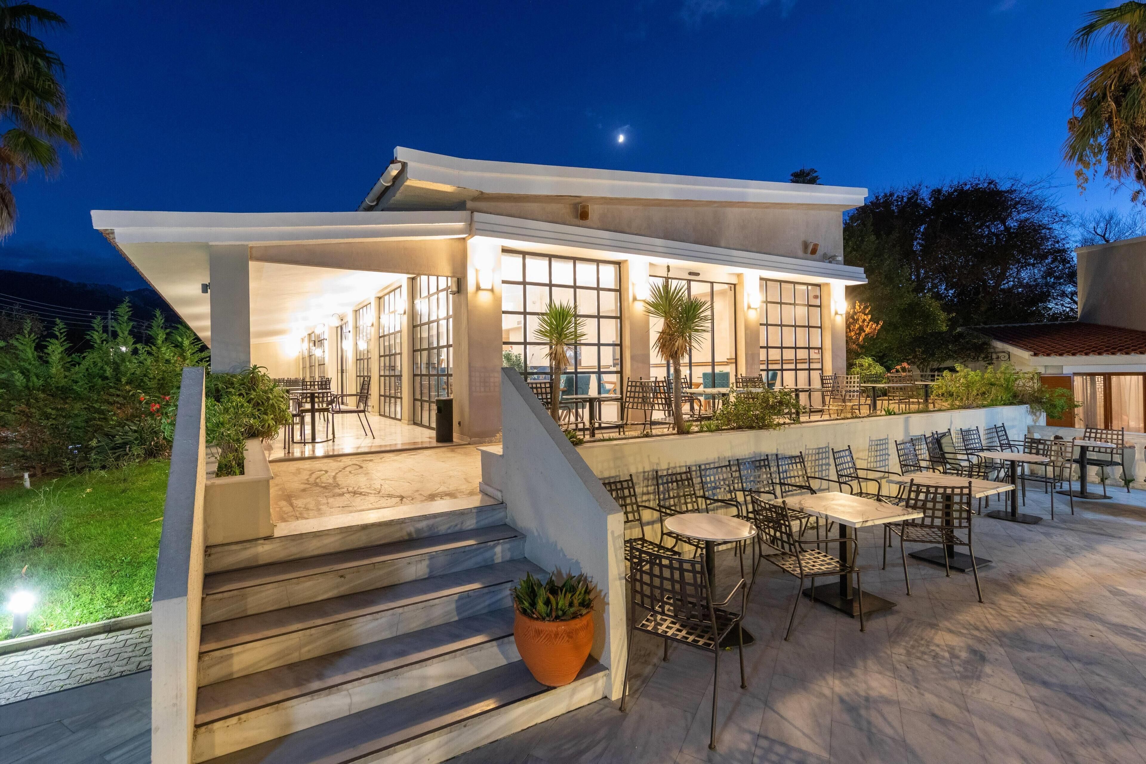 A modern outdoor patio with seating and a staircase leading to an upper level.