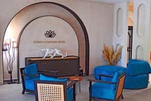 A lobby with a reception desk, seating area, and a wall with a logo and text.