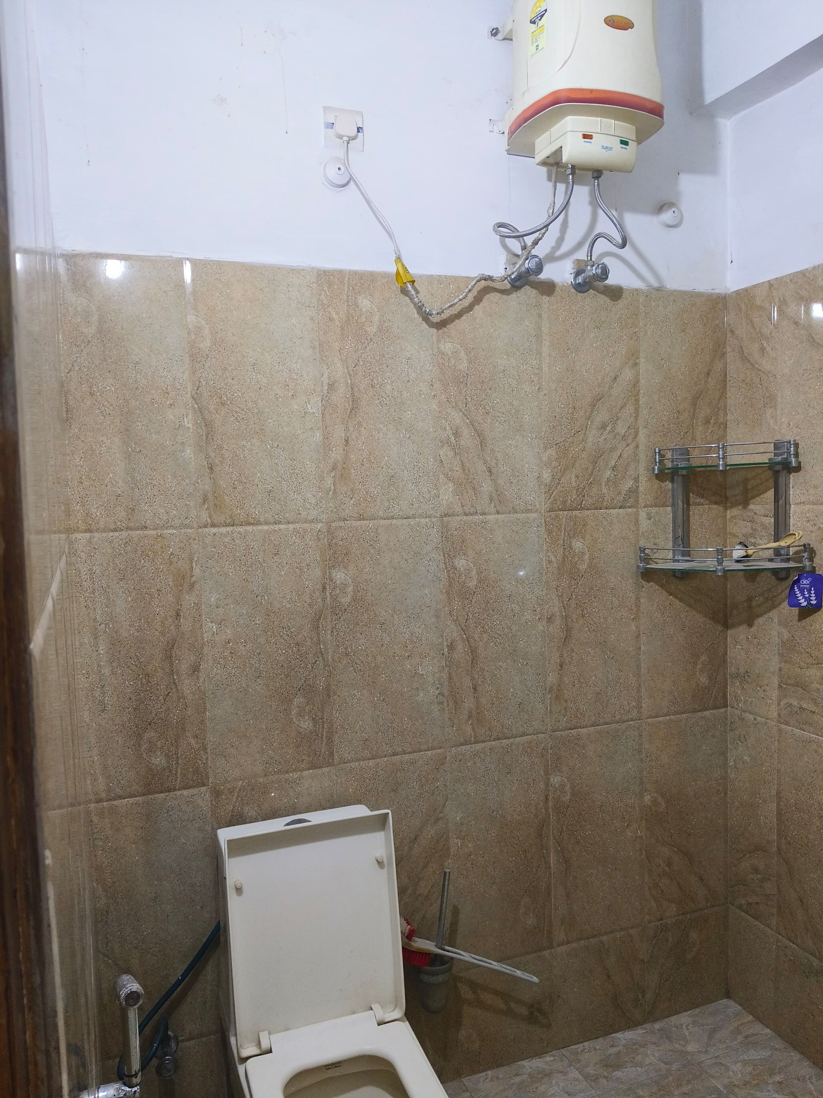 Ein Badezimmer mit Toilette, Dusche und einem Handtrockner.