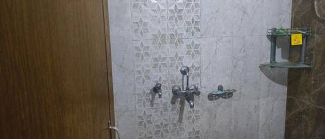 A bathroom with a shower, a sink, and a red basin.
