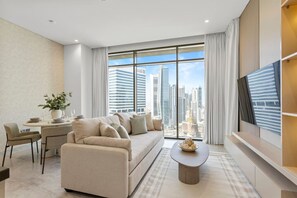 A modern living room with a sofa, a dining table, and a TV.