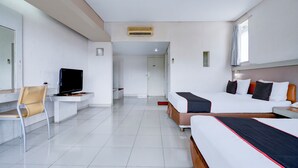Una habitación de hotel con cama, escritorio, silla y televisión.