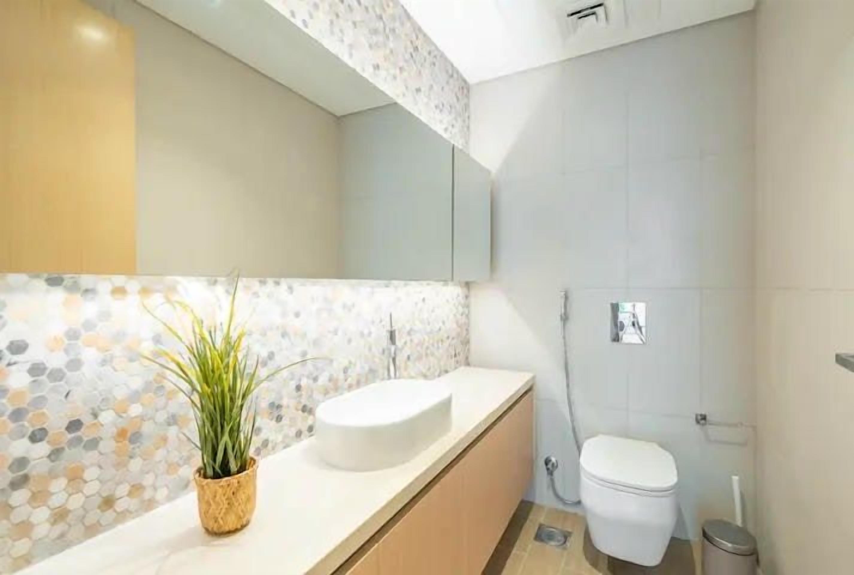 Een badkamer met een wit wastafelmeubel, toilet en douche.