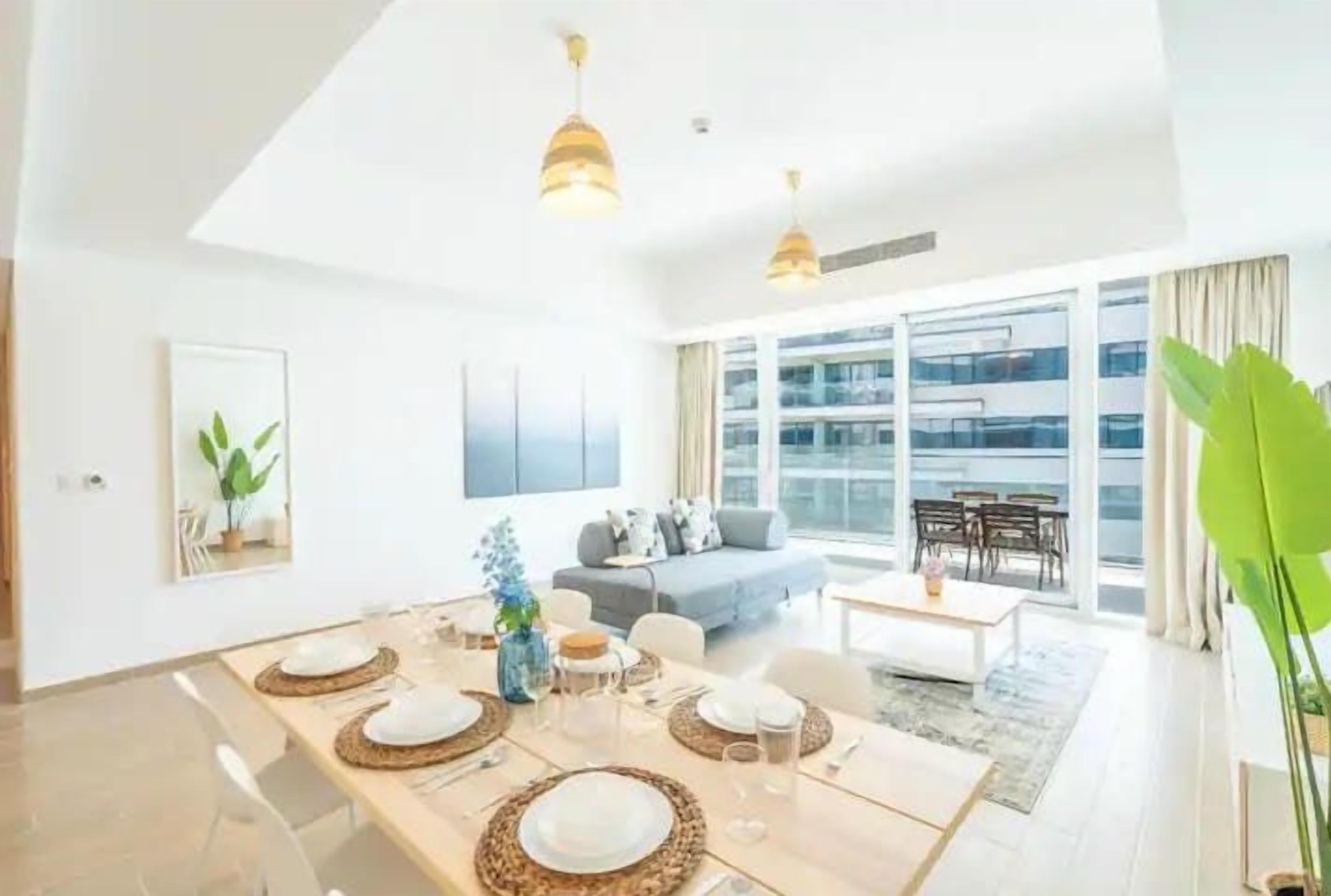 Un salon moderne avec un coin repas, de grandes fenêtres et une vue sur la ville.
