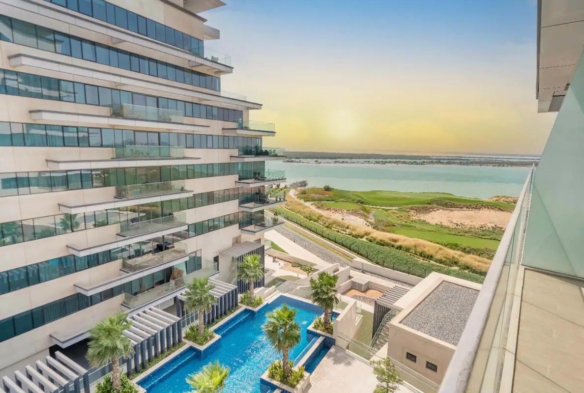 Un bâtiment moderne doté d’une piscine sur le toit et offrant une vue sur la mer.
