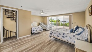 A bedroom with two beds, a ceiling fan, and a balcony with a view. - 2740 Shore Ln - 1 block to the peach - Pet Friendly!  Large Home (Boca Grande)