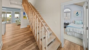 Een ruime kamer met een houten wenteltrap naar een balkon.