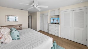 A bedroom with a bed, a ceiling fan, a TV on a dresser, and white closets. - Sundown 03:  2-bed, 2-bath townhome in Boca Grande stunning Gulf front views, a relaxing getaway. (Boca Grande)