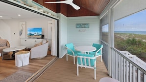 A cozy balcony with wooden flooring, a white ceiling fan, and a view of Boca Grande Beach. - Luxury Seagrape 01, 3-bedroom, 3-bathroom townhome in Boca Grande with stunning Gulf views. (Boca Grande)