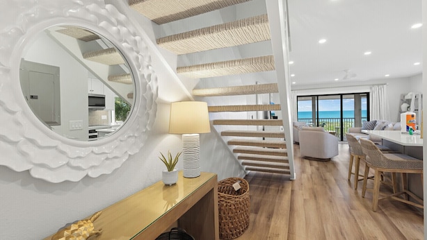 A modern interior with a staircase, a dining area, and a view of the ocean. - Luxury Seagrape 01, 3-bedroom, 3-bathroom townhome in Boca Grande with stunning Gulf views. (Boca Grande)