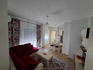 Familieleilighet, balkong, byutsikt | Oppholdsområde | En 32-tommers smart-TV med digitale kanaler