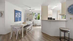 A modern kitchen with white cabinetry, a built-in microwave, and a large window. - Charming Spacious 2-Bedroom Getaway in Central Burleigh Heads (Gold Coast)