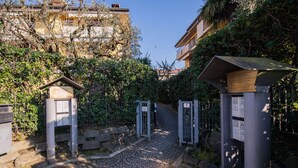 A gated entrance with a cobblestone path leading to a building. - Villaggio dei Fiori - App Primula (Sirmione)