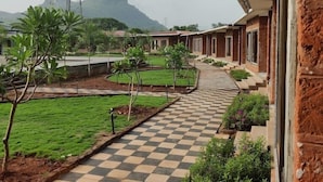 A hotel corridor with a checkered floor, a view of a mountain, and a communication tower in the distance.