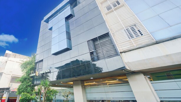 A modern building with a glass facade, large windows, and a visible entrance. - Hotel O Tanjung Duren Near Mall Citraland Formerly Suba Hotel (Jakarta)