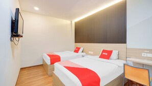 A hotel room with two beds, a TV mounted on the wall, and a desk with a chair. - Hotel O Tanjung Duren Near Mall Citraland Formerly Suba Hotel (Jakarta)