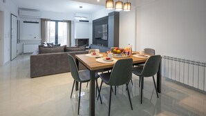 Un comedor moderno con una mesa de madera, cuatro sillas y un frutero.