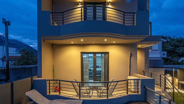 Una casa moderna de dos pisos con un balcón y una piscina.