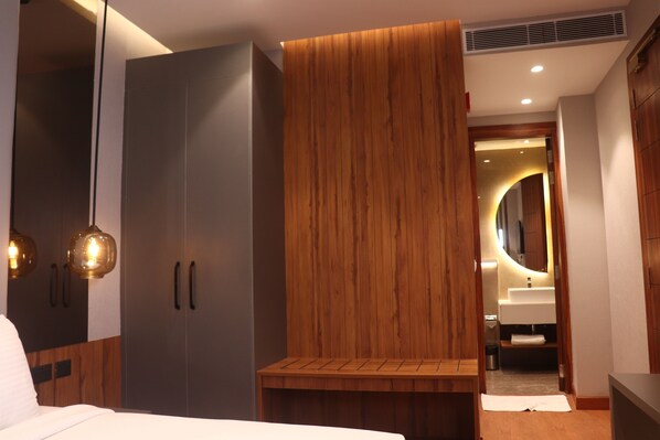 Un dormitorio moderno con un armario grande, una mesita de noche y una lámpara colgante.