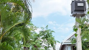 A residential area with a two-story house, a utility pole with electrical equipment, and a parked motorcycle. - Asoca Hotel Luang Prabang (Luang Prabang)