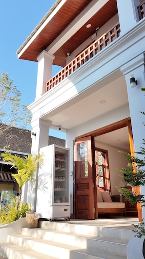 A two-story house with a balcony, a front door, and a refrigerator. - Asoca Hotel Luang Prabang (Luang Prabang)