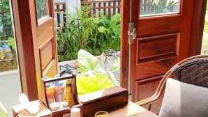 A breakfast setup with plates of food, a glass of juice, and a cup of coffee on a table by a window with a view of greenery and a building. - Asoca Hotel Luang Prabang (Luang Prabang)