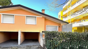 Un bâtiment à deux étages, doté d’un toit plat, d’un garage et d’une clôture verte.
