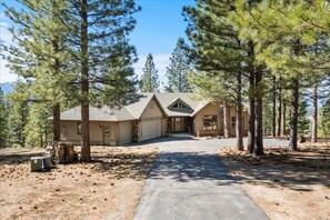 A two-story house with a garage, surrounded by tall pine trees. - Mountaintop Cabin Hot Tub Views Family Golf (Portola)