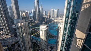 Un immeuble de grande hauteur offrant une vue sur un paysage urbain, avec plusieurs gratte-ciel et une vaste étendue d’eau.