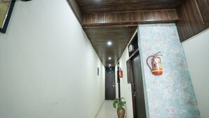 A hallway with a wooden ceiling, a potted plant, and a fire extinguisher.