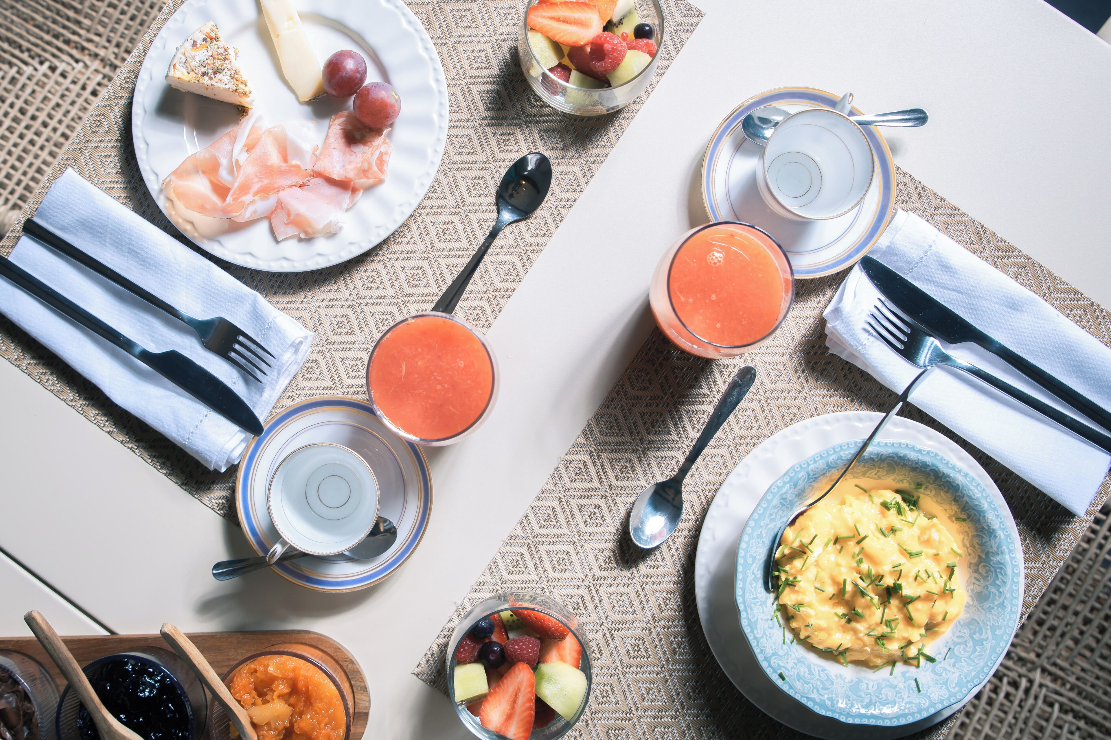 Desayuno con platos de comida, vasos de jugo y un tazón de sopa.