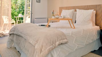 Un dormitorio con cama, mesita de noche y vista a zonas verdes.